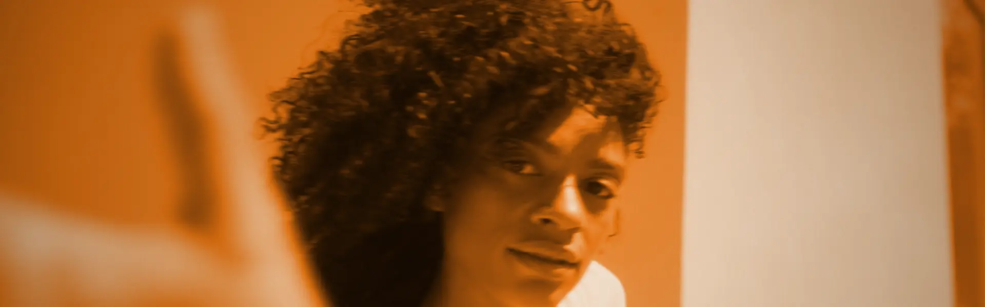 Header. Eine Junge Frau tanzt alles ist Orange eingefärbt