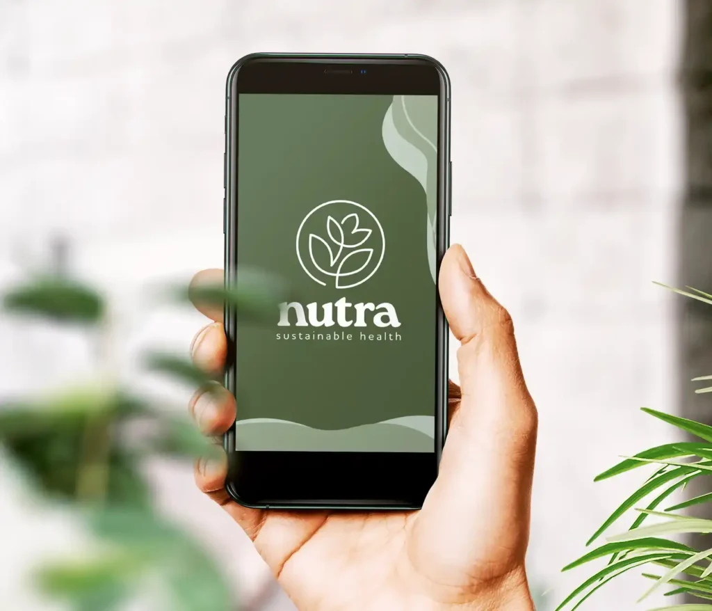 Eine Hand die frontal ein Smartphone mit der Startseite der Nutra App zeigt.